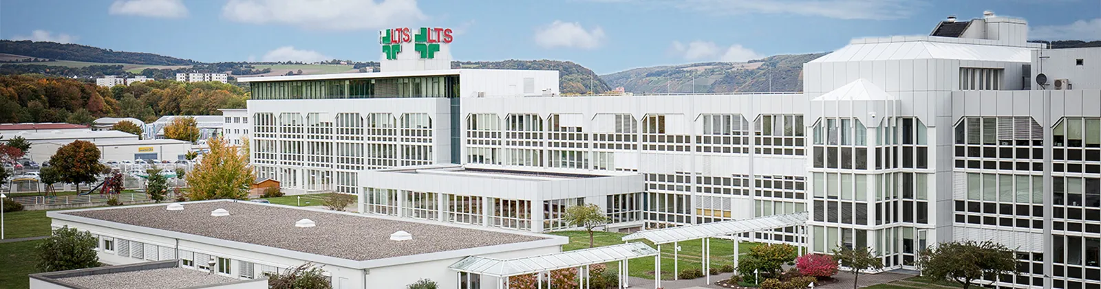 LTS-Unternehmensgebäude in Andernach mit mehrstöckiger, weißer Fassade und LTS-Logo auf dem Dach.