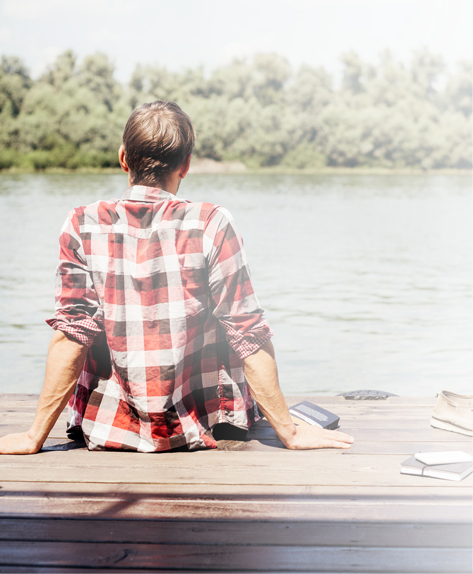 Ein Mann sitzt auf einem Holzdeck und schaut auf einen kleinen See: LTS bietet Stabilität und Sicherheit.
