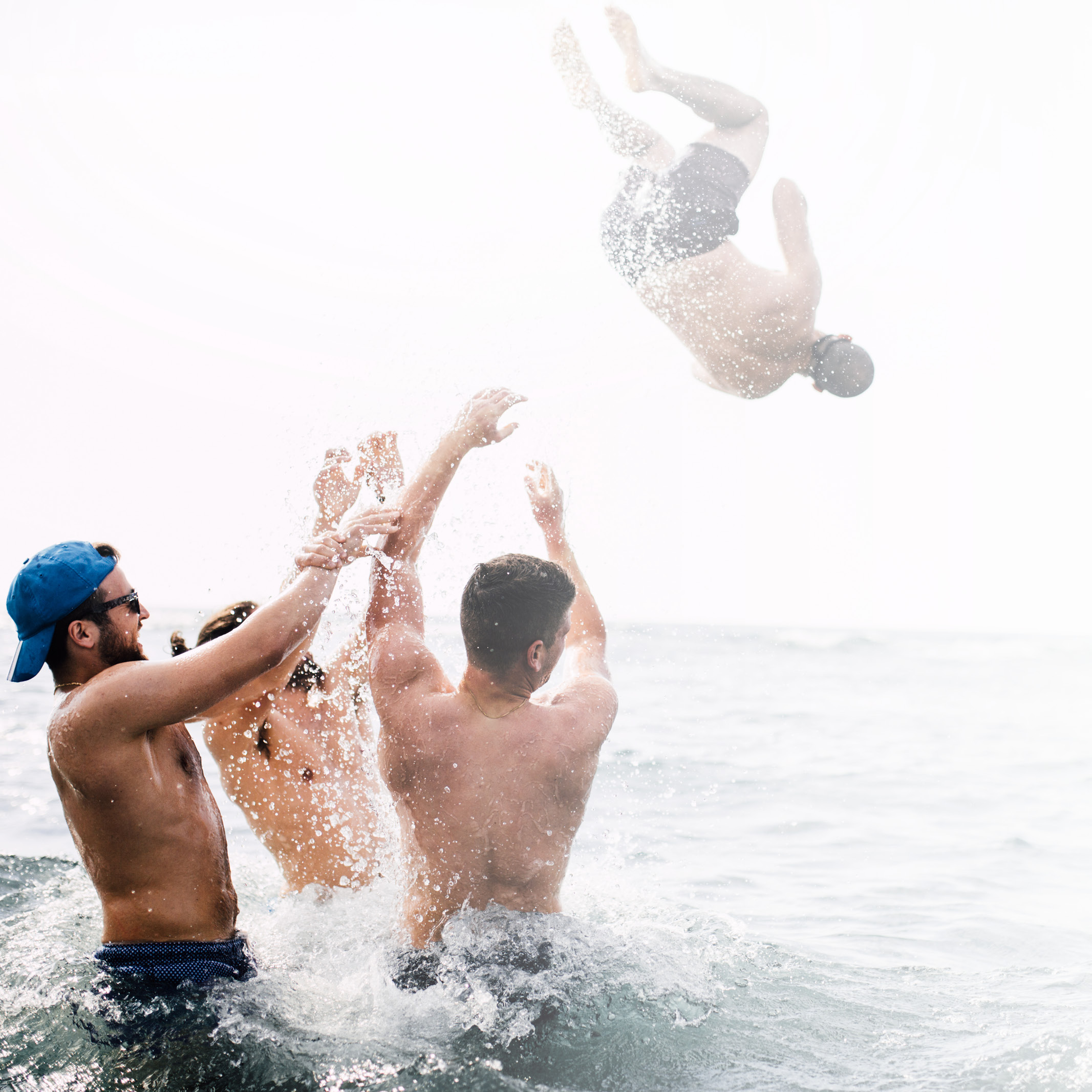 Drei Männer stehen hüfttief im Meer werfen einen vierten Mann ins Wasser: Dein Weg. Deine Zukunft. Dein LTS. Karriere bei LTS Lohmann Therapie-Systeme.
