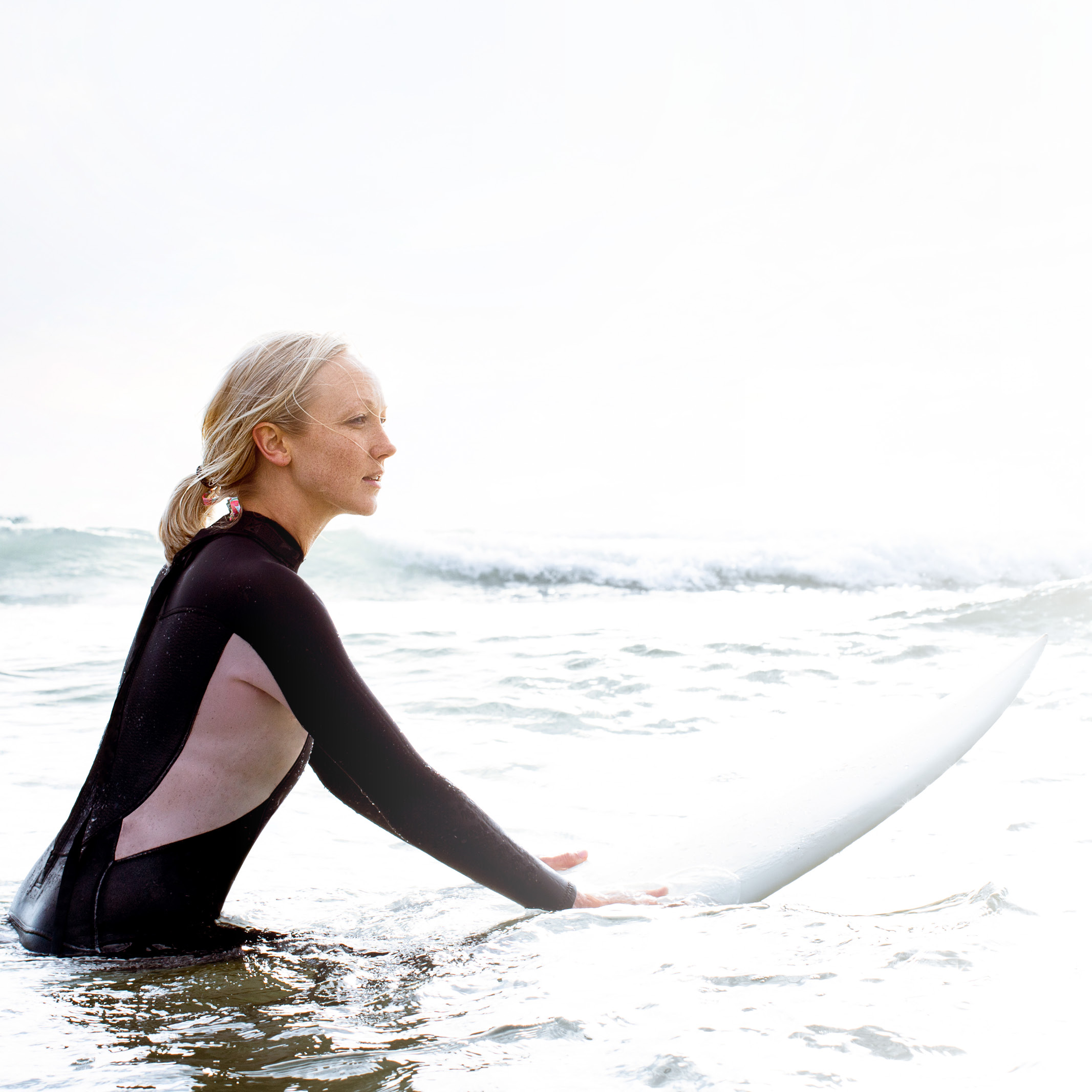 Frau im Surfanzug und Surfboard im Wasser: Erlebe den Flow: Dein Weg. Deine Zukunft. Dein LTS.