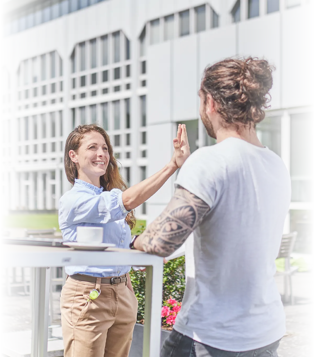 Zwei LTS-Mitarbeiter geben sich lachend vor dem LTS-Gebäude in Andernach einen High-Five.